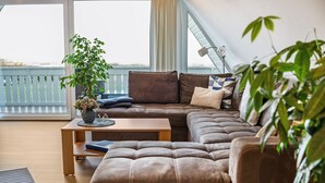 Een moderne woonkamer met een modulaire bank, een klein tafeltje en een potplant.