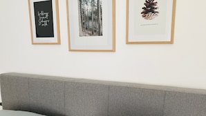 Una cama con almohadas y tres cuadros en la pared.