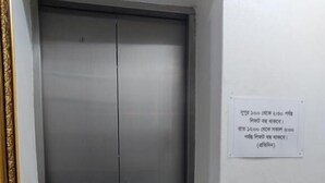 Un ascensor con panel de control y señal que indica el horario de funcionamiento.