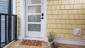 A front door with a glass panel, a doormat, a potted plant, and a mailbox. - Cozy, Bran New Private fully furnished studio downtown Chilliwack.  (Chilliwack)