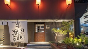A hotel entrance with a banner reading "YOSURI GURI THE BUREAU HOTEL" and a wooden door. - Anook Ryokan Yosuriguri Hotel (Cheonan)