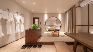 A modern hotel room with a large mirror, a wooden bench, a small table, and a plant. - Anook Ryokan Yosuriguri Hotel (Cheonan)