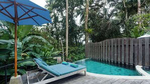 A wooden deck with a pool, lounge chairs, and a blue umbrella. -  Sacred Beji by GenuineHost (Payangan)