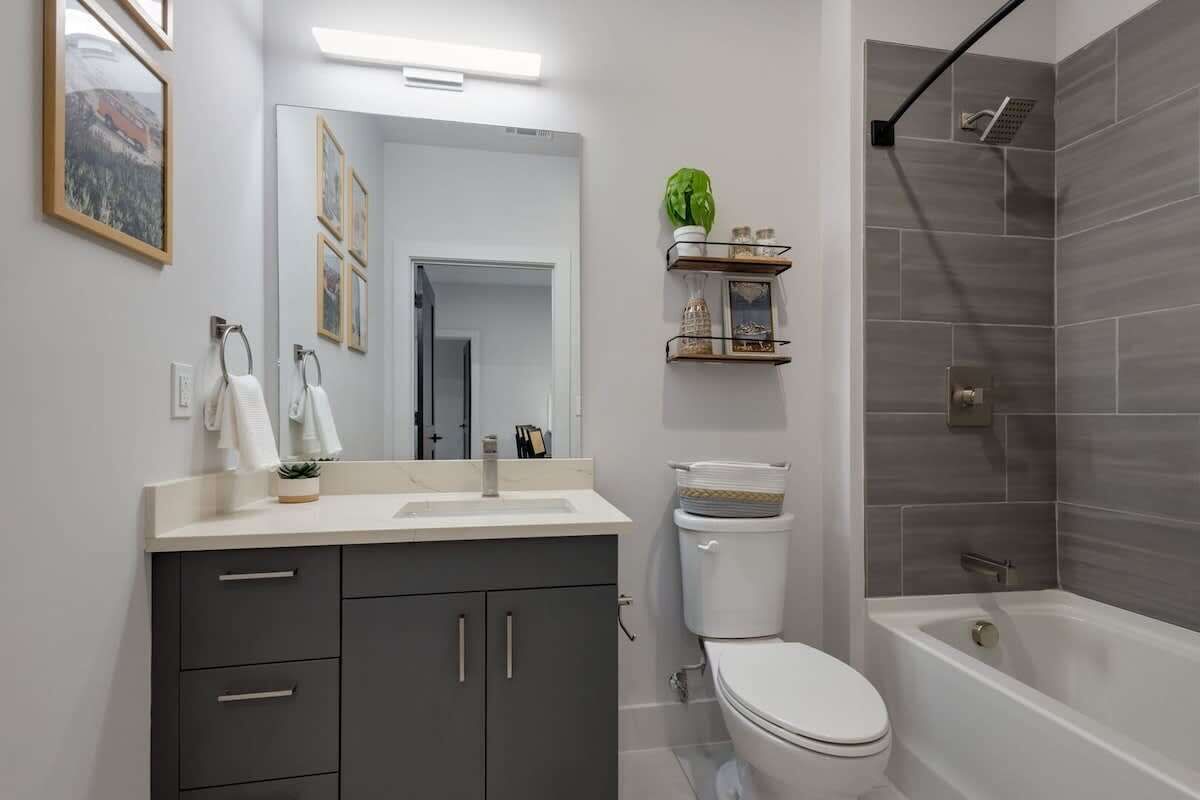 A bathroom with a toilet, sink, vanity, and shower.