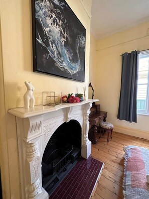 A room with a fireplace, a painting above it, and a window with curtains. - Altam House, Ballarat Central (Ballarat Central)