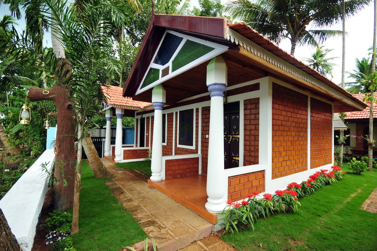 A traditional house with a tiled roof, white columns, and a brick exterior.