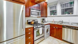 A kitchen with wooden cabinets, stainless steel appliances, a stove, oven, microwave, and dishwasher.