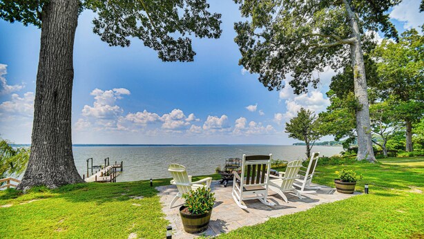 A lakeside patio with outdoor seating and a dock. - Waterfront Gloucester Cottage w/ Private Boat Dock (Gloucester)