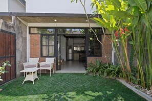 A modern house with a glass door leading to a kitchen and dining area. - Jaci Residence Umalas By Betterplace (Kerobokan)