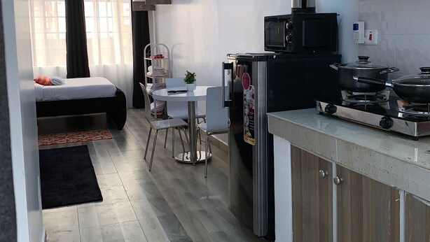 A compact living space with a kitchenette, a dining area, and a bedroom.