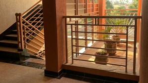 A staircase with a metal railing leading to a balcony with potted plants.