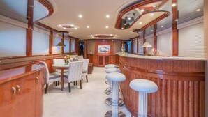 A luxurious interior with a bar area, seating, and a large painting on the wall. - Stonehedge at Sea (Fort Lauderdale)