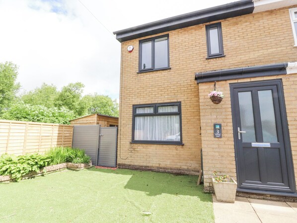 A two-story brick house with a dark front door, a small front garden, and a wooden fence. - 3 Thrimby Court (Morecambe)