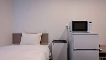 Ein Hotelzimmer mit einem Bett, einer Mikrowelle und einem Kühlschrank.