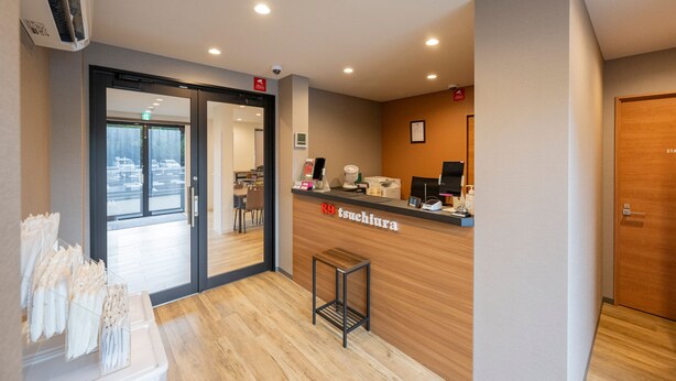 A reception area with a wooden counter, a coffee machine, and a framed picture on the wall. - HOTEL R9 The Yard Tsuchiura (Tsuchiura)