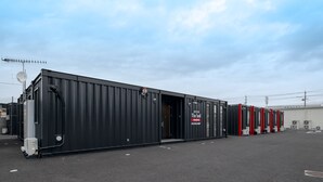 A large industrial building with a black exterior, a door, and a sign that reads "The Land - 5th Floor - 5th Floor". - HOTEL R9 The Yard Tsuchiura (Tsuchiura)