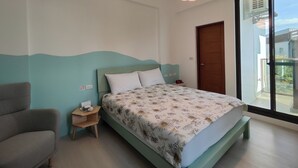 A bedroom with a bed, a bedside table, a chair, and a window with a view. - Nan Ping Ourhill B&B (Dongshan)