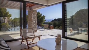 A modern interior with a large glass door leading to an outdoor patio area.