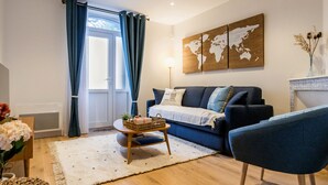A modern living room with a blue sofa, a coffee table, and a world map artwork on the wall.