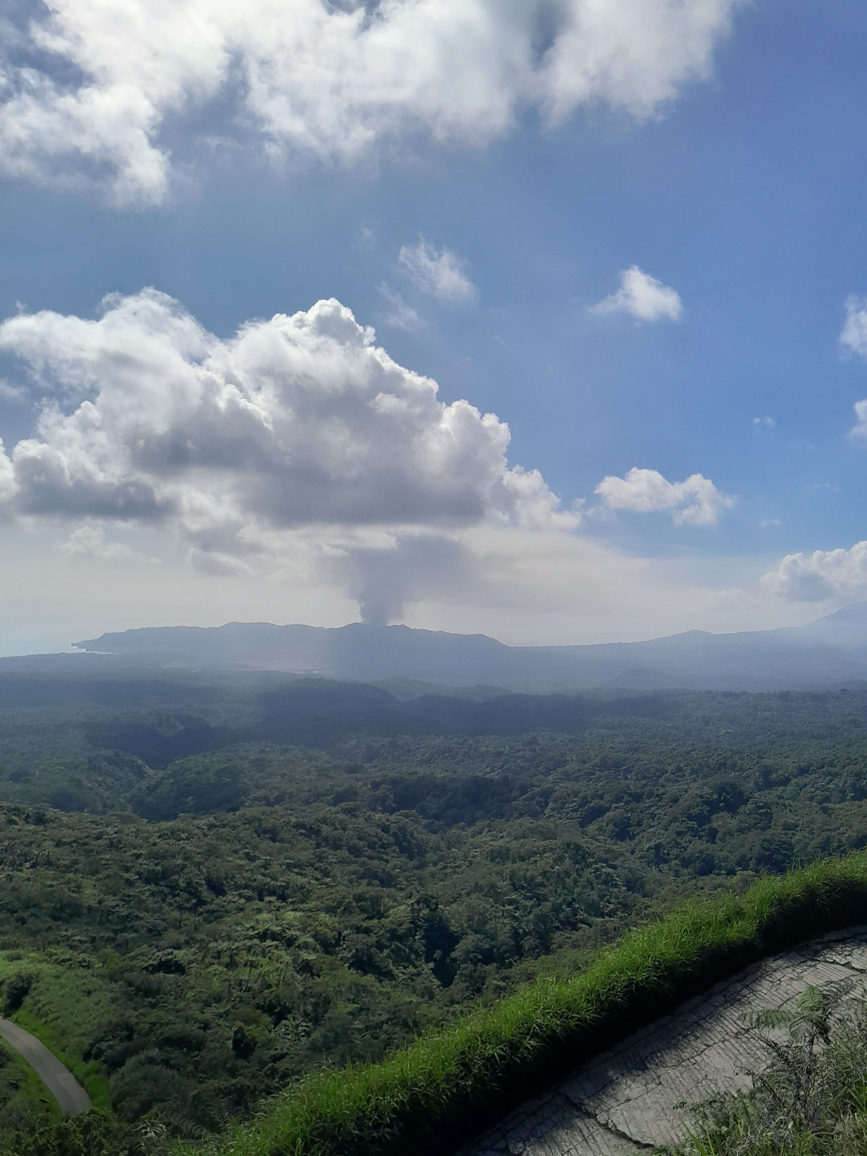 Un paysage montagneux, avec une végétation luxuriante et une route sinueuse.