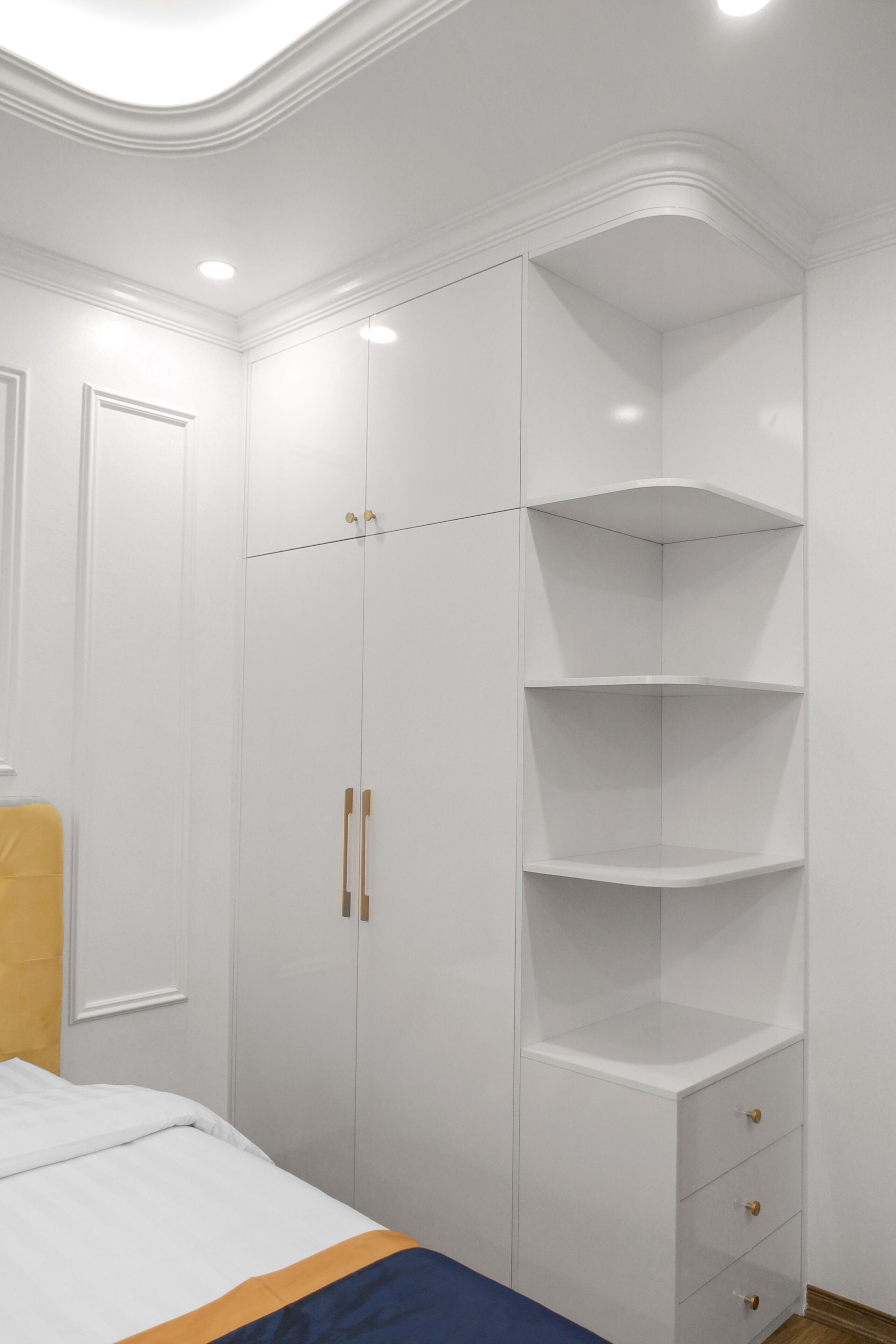 A bedroom with a bed, a wardrobe, and a built-in shelving unit.