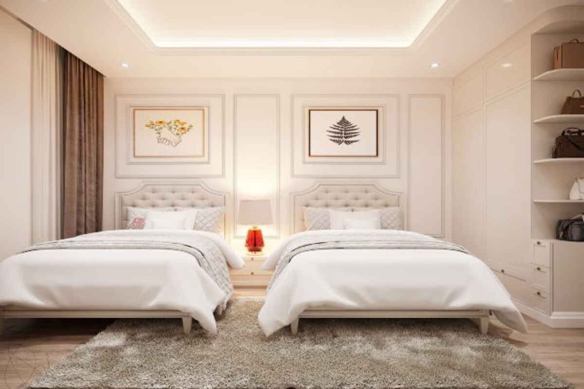 Une chambre avec deux lits, un lustre et une armoire.