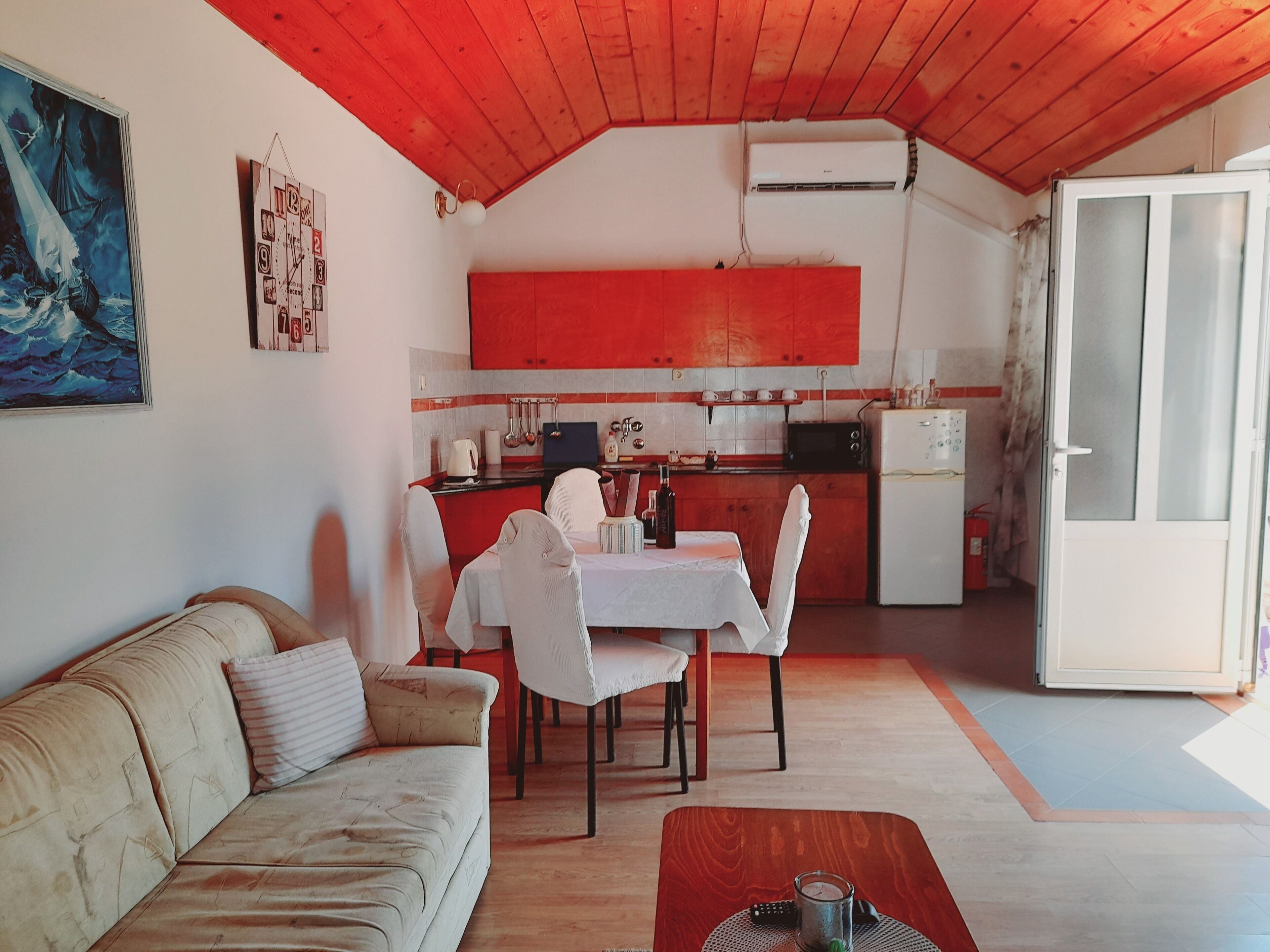 A compact living space with a kitchenette, a dining area, and a sofa.
