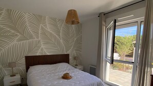 A bedroom with a bed, a nightstand, a lamp, a ceiling light, and a view of the outdoors. - Beautiful AC T2 for 4, terrace and parking in Port Leucate (Port Leucate)