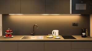 A modern kitchen with a built-in oven, a sink, and a coffee maker. - SUITE DELLA PIGNA (Rome)