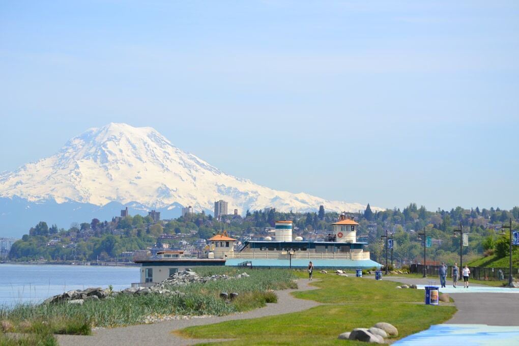 A coastal building with a view of a snow-capped mountain in the background.