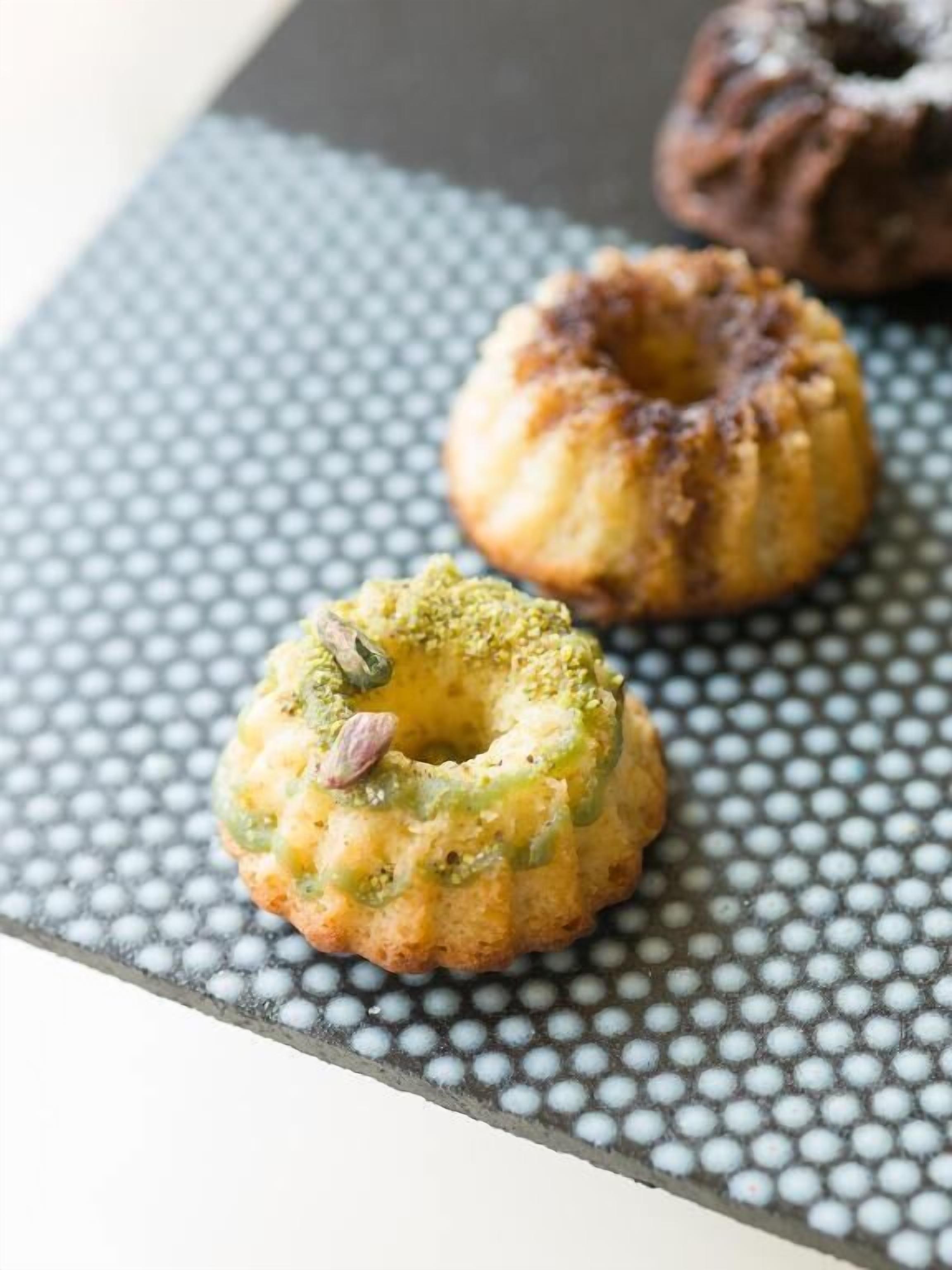 Twee kleine, ronde gebakjes op een gestructureerd oppervlak.