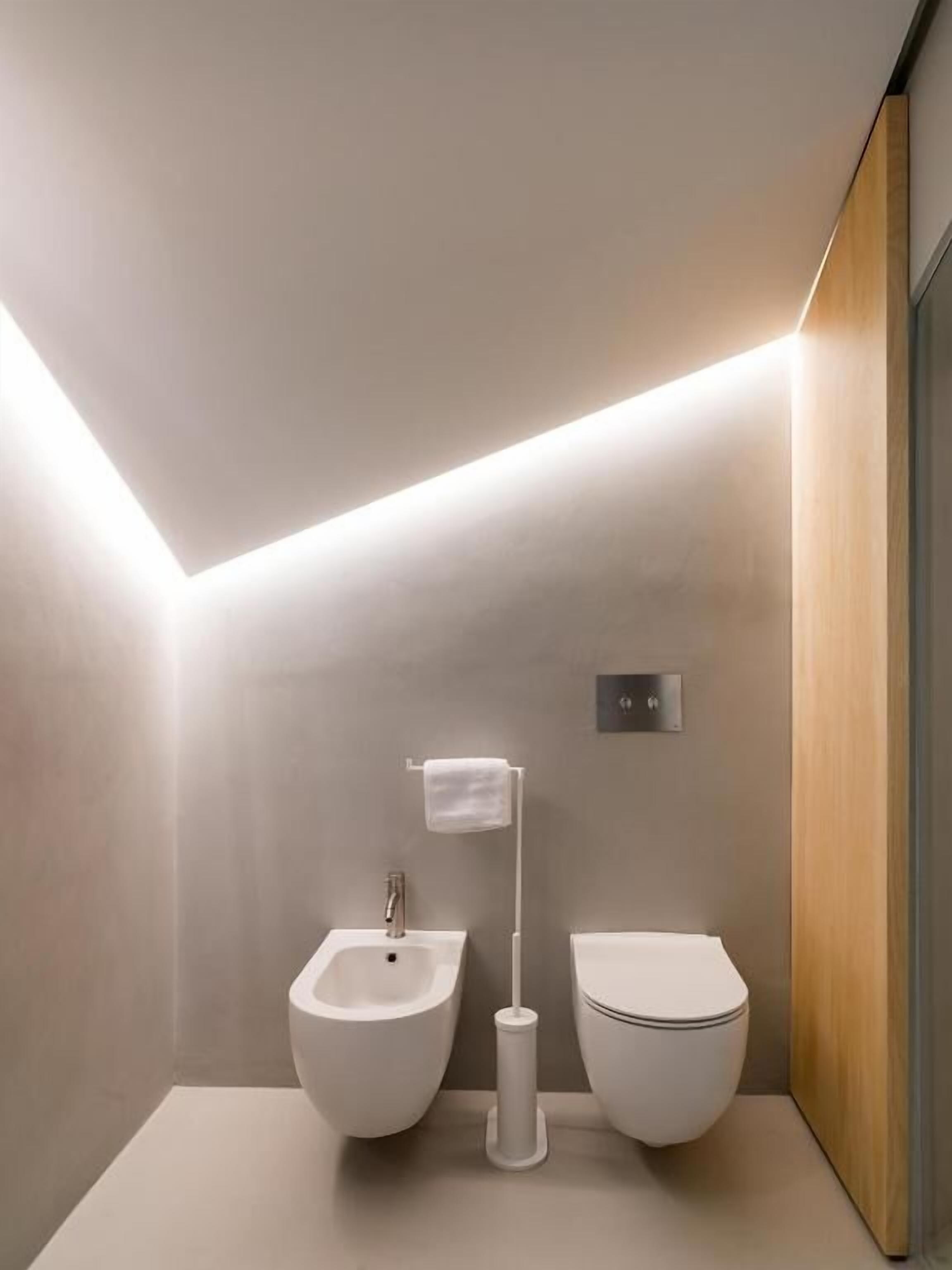 A modern bathroom with a bidet, toilet, and a towel rack.