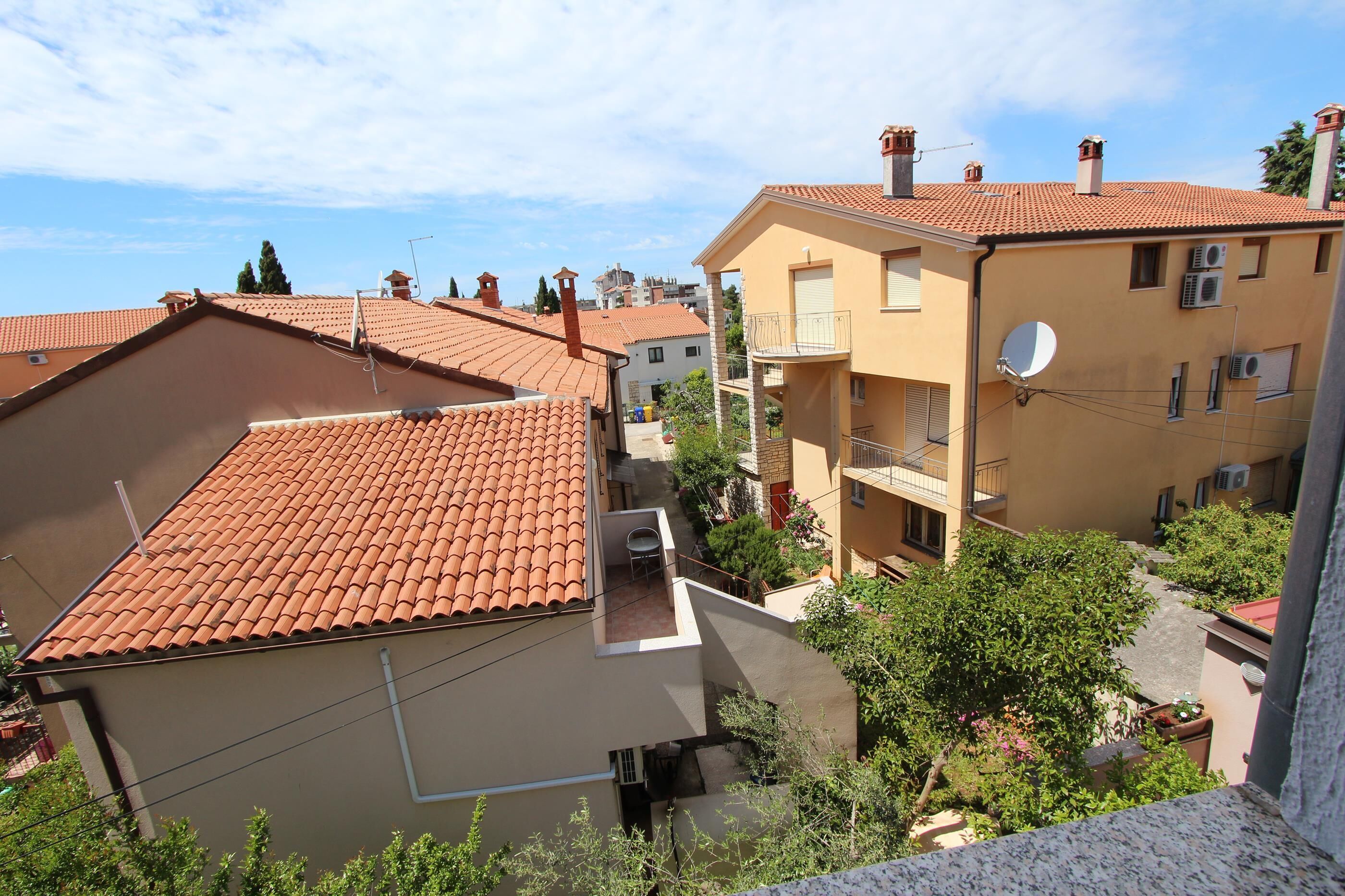 Un barrio residencial con techos de tejas de terracota, balcones y antenas parabólicas.