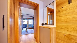 A wooden interior hallway leading to a balcony with a view. - Stylish Alpine Retreat for 4 – Walk to Slopes with Alpspitze Views & Balcony (Garmisch-Partenkirchen)
