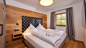 A modern hotel room with a wooden headboard, a large window with curtains, and a neatly made bed with white linens. - Stylish Alpine Retreat for 4 – Walk to Slopes with Alpspitze Views & Balcony (Garmisch-Partenkirchen)