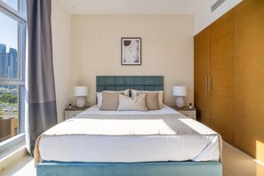 A modern bedroom with a large bed, two bedside tables, a city view, and a wooden wardrobe.