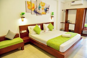 Une chambre d’hôtel comprenant un lit, un banc, une armoire et des œuvres d’art accrochées au mur.