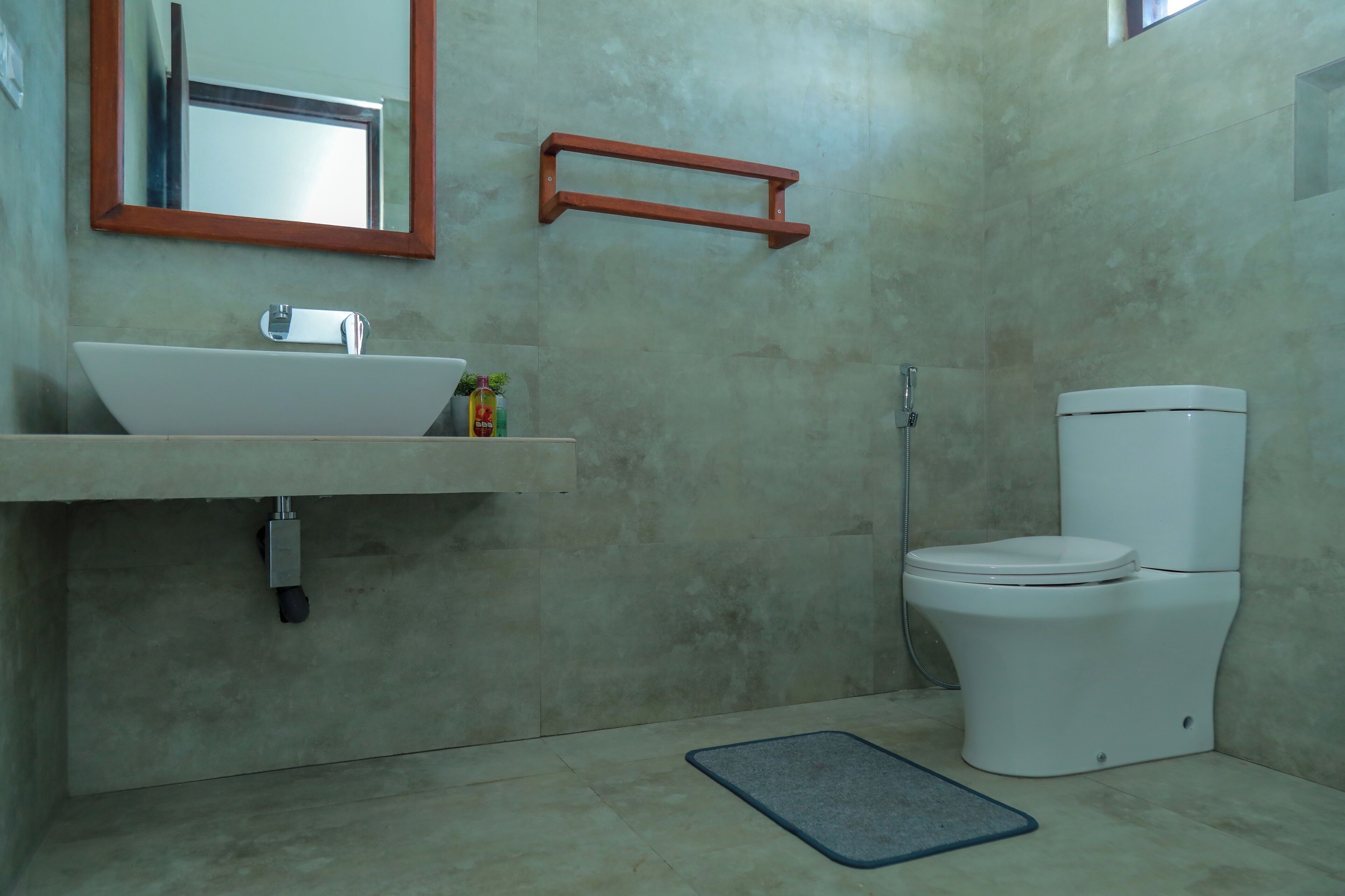 A bathroom with a white sink, mirror, and toilet.