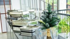 Un buffet agrémenté de beaux verres et d’un petit sapin de Noël artificiel.