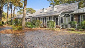 A residential property with a covered driveway, a brick exterior, and a front porch.