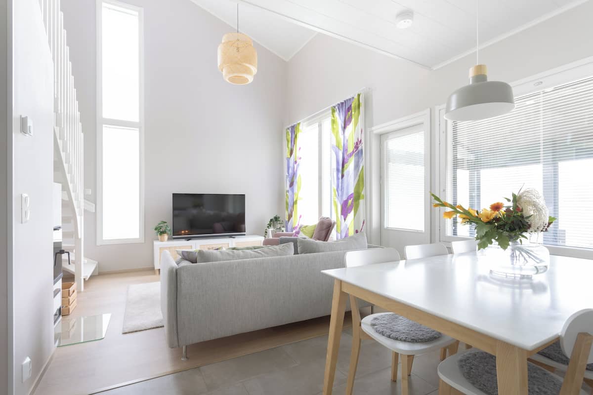 A modern living room with a sofa, dining table, and TV.