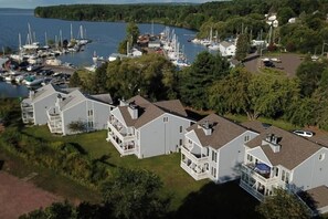 A marina with multiple boats docked, surrounded by residential buildings with balconies and large windows. - 1BR Condo | Bayfield Lake View (Bayfield)
