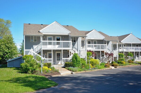 A row of two-story townhouses with front porches and a small attached garage.