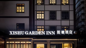 The exterior of XISHU GARDEN INN with traditional Chinese window designs and a modern entrance. - XISHU GARDEN INN (Chengdu)