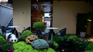 A garden with a panda statue, a fountain, and outdoor seating. - XISHU GARDEN INN (Chengdu)