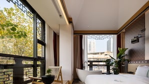 A modern hotel room with a large window, a bathtub, and a bed with a green stripe. - XISHU GARDEN INN (Chengdu)
