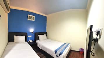 A room with two beds, a small window, a wall-mounted TV, and a power outlet.