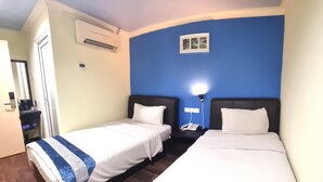 A hotel room with two single beds, a small bedside table with a lamp, and a wall-mounted air conditioning unit. - Hotel Sunjoy9 Klang (Klang)