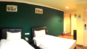 A hotel room with two beds, a door, and a small trash bin. - Hotel Sunjoy9 Klang (Klang)