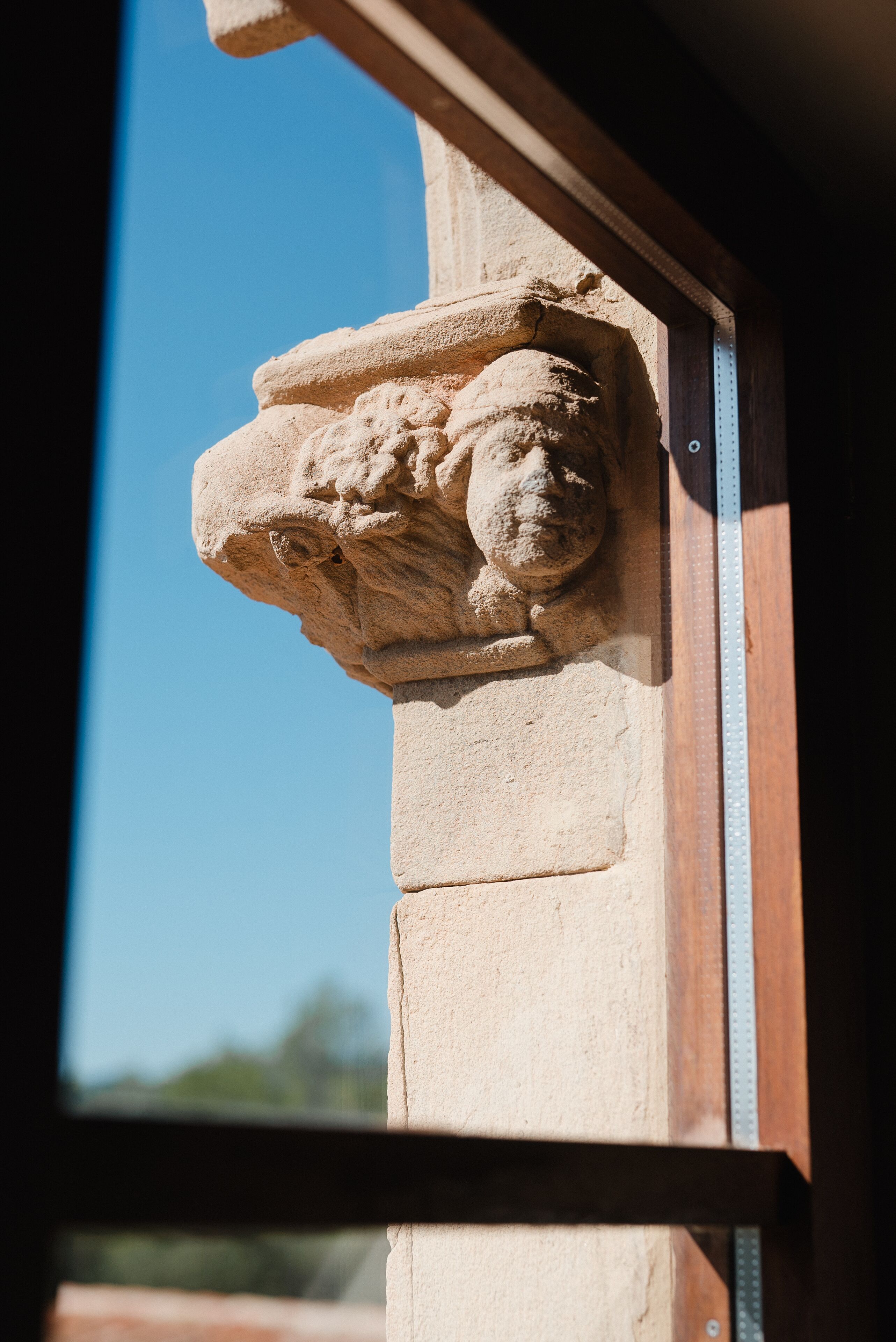 A stone architectural detail with a protruding element, possibly a decorative feature, attached to a wooden structure.